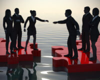Two teams of successful executives merging on a jigsaw puzzle at sunset showing a partnership.